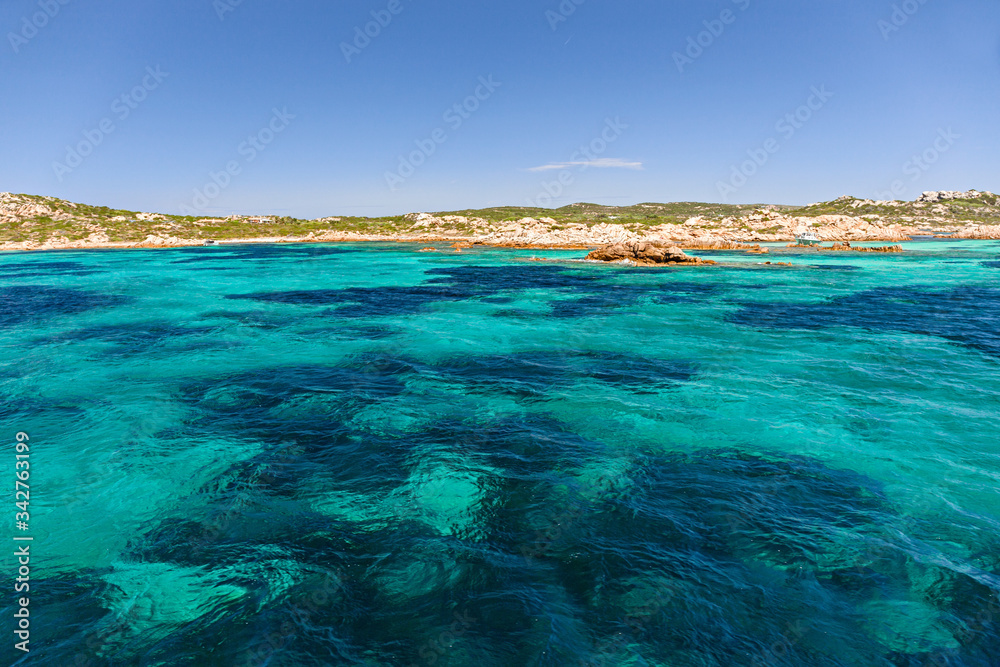 Fototapeta premium Panoramic view of the pink granite rock formations and the clear and transparent waters in the Maddalena archipelago in Sardinia, Italy.