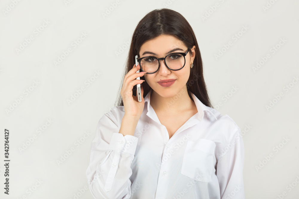 beautiful young woman in glasses on a white background with a phone	