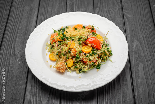 salad with bulgur and vegetables, Tabbouleh, on a dark wood background. tinting.