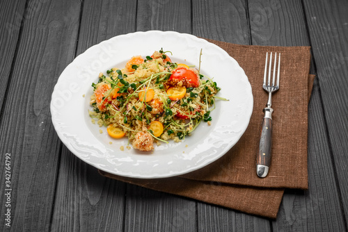salad with bulgur and vegetables, Tabbouleh, on a dark wood background. tinting.