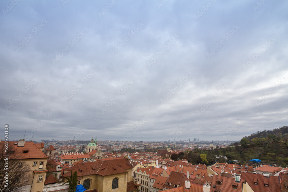 Panorama of Prague, Czech Republic, seen from the top of the castle, during an autumn cloudy afternoon. Major tourist landmarks such as medieval towers, cathedrals and churches, are visible