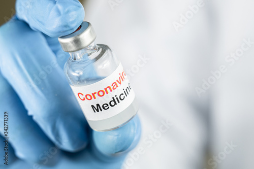 Doctor or nurse hand holding coronavirus vaccine, covid-19 medicine for people immunization, health care concept (select focus)