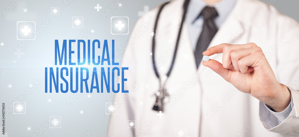 Close-up of a doctor giving a pill with MEDICAL INSURANCE inscription, medical concept Close-up of a doctor giving a pill with MEDICAL INSURANCE inscription, medical concept