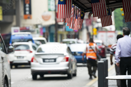 (Focus on the flags) View of some Malaysian national flags in the foreground and a blurred road in the background. The name of the national flag is Jalur Gemilang meaning 'Stripes of ExcellenceÕ. photo