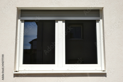 Moderne Fenster in einer gemauerten  verputzten und gestrichenen Fassade eines modernen Wohnhauses