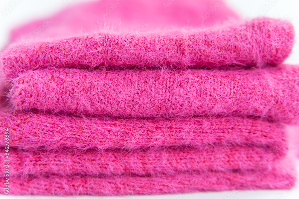 Pattern of pink knitted sweater closeup. A stack of folded clothes Pattern of pink knitted sweater closeup. A stack of folded clothes