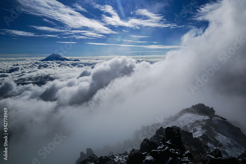 ILINIZA VOLCANO, ECUADOR - DECEMBER 03, 2019: View towards Cotopaxi volcano emerging above the clouds