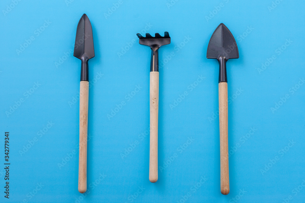 Garden tools, shovel, rake on a blue background Garden tools, shovel, rake on a blue background