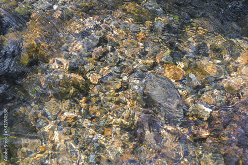rocks and pebbles at bottom of riverbed through clear water