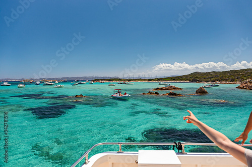 Slika na platnu Various tourist boats are stationed in the clear and transparent waters in the Maddalena archipelago in Sardinia, Italy