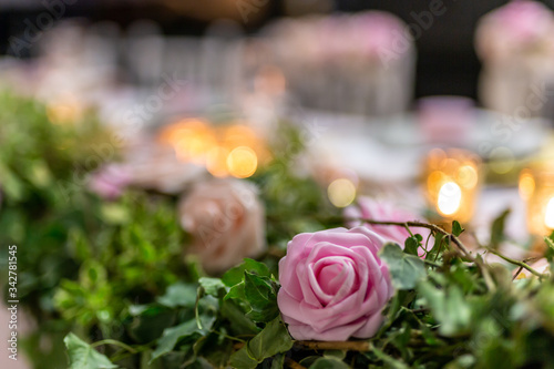 Closeup shot of a wedding pink rose decorating the couple table. 