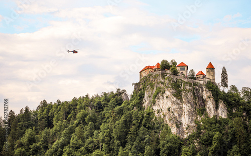 Helicopter flying towards the castle in Bled, Slovenia photo