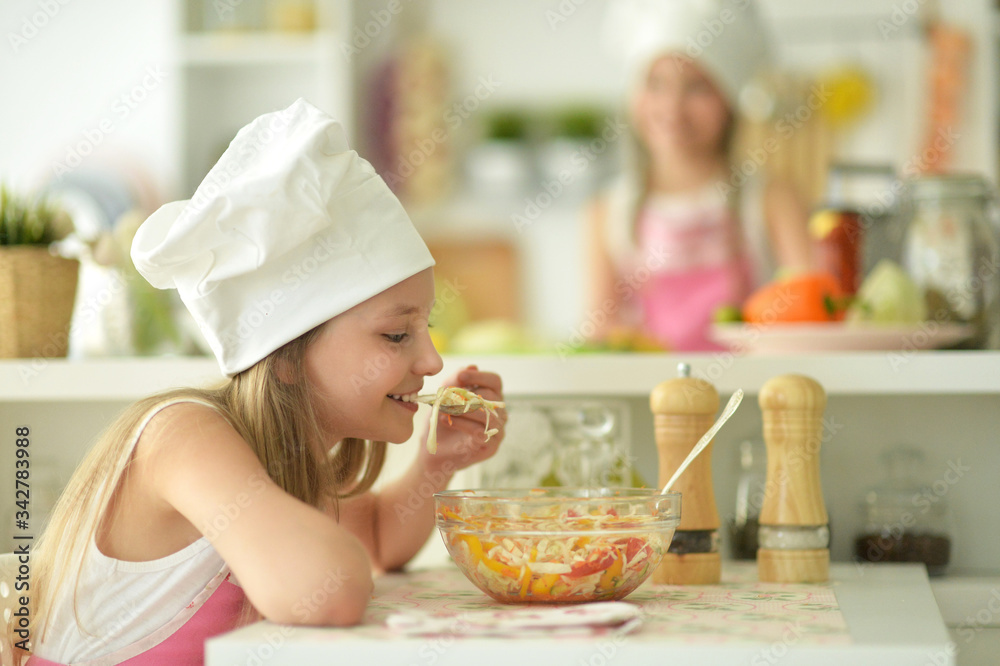 Portrait of cute girl eating salad on kitchen Portrait of cute girl eating salad on kitchen