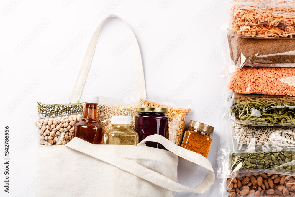 Group of colorful various cereals, seeds, nuts and legumes in plastic wrap.