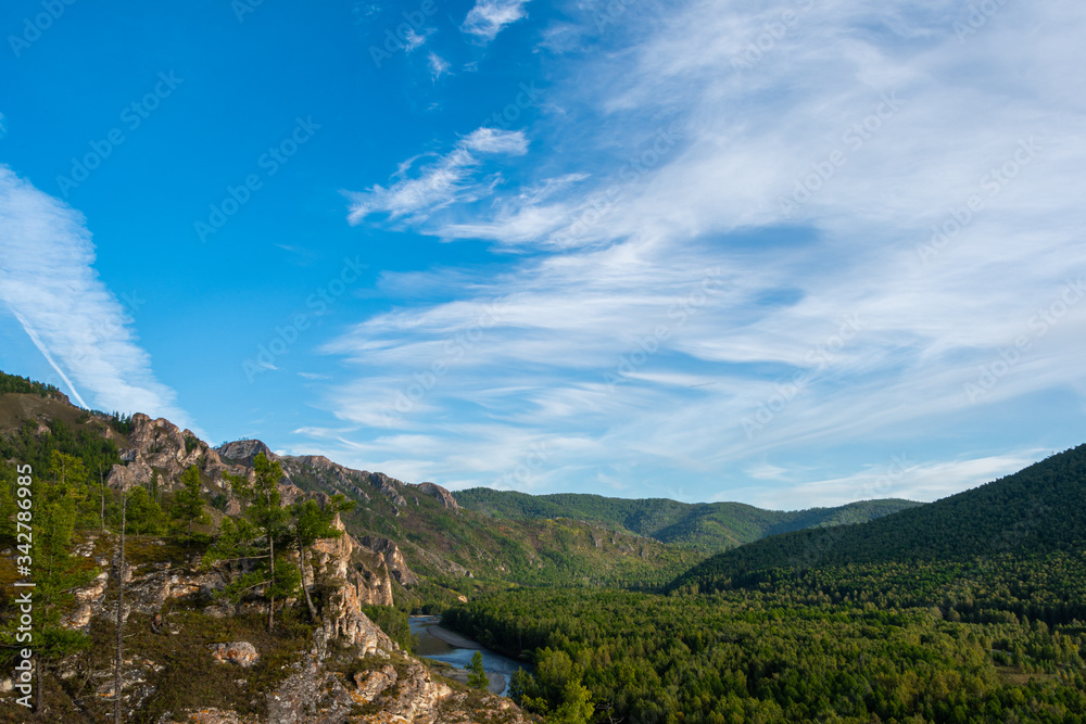 gentle green hills under blue cloudy sky, panorama of mountain landscape, valley for summer hiking