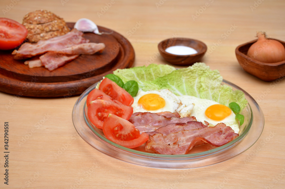 breakfast of fried eggs with bacon and vegetables on a plate