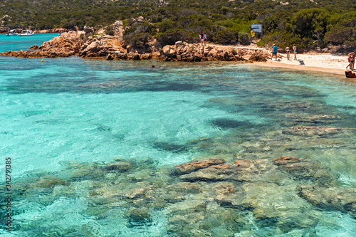 Some swimmers tan on the sunny beaches of the island of Maddalena in Sardinia, Italy.