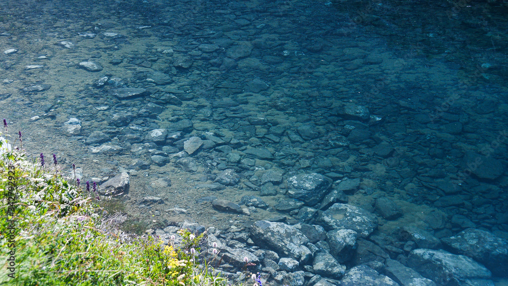 rocky shore of sea, fast river in mountain valley, ocean surf on summer day