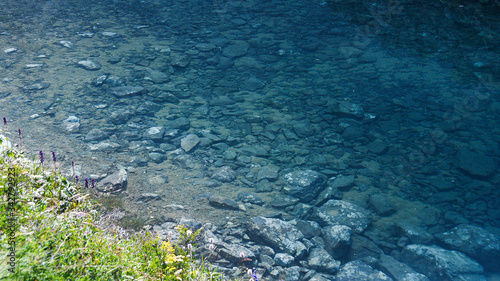 rocky shore of sea, fast river in mountain valley, ocean surf on summer day