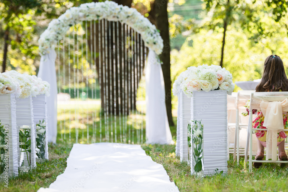 Fototapeta premium White luxury wedding ceremony decorations outdoor in the summer park. Table, chairs and weddinh decorated arch