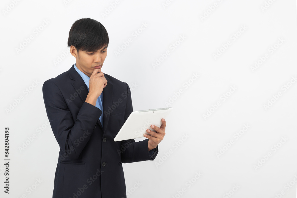 Young asian businessman in black suit using tablet computer isolated on white background, Online shopping, Remotely working. Young asian businessman in black suit using tablet computer isolated on white background, Online shopping, Remotely working.