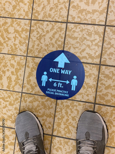 Man waits in a checkout line while practicing social distancing during the COVID-19 pandemic of 2020.