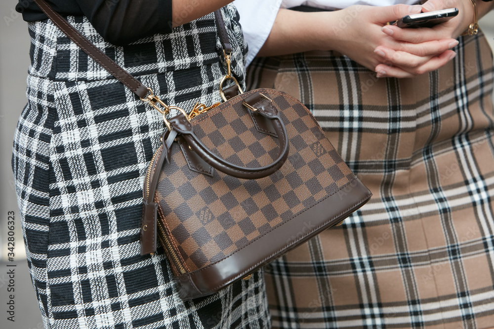 Woman with brown Louis Vuitton checkered bag on September 22, 2018 in  Milan, Italy Stock Photo