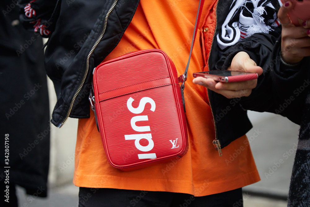 Foto Stock Man with orange shirt and red Louis Vuitton Supreme bag on  January 15, 2018 in Milan, italy | Adobe Stock