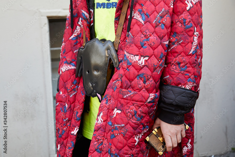 Obraz premium Man with red Spider Man coat and Louis Vuitton phone cover on January 13, 2019 in Milan, Italy