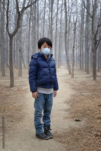 Young Asian boy wearing face mask to protect against air pollution   Beijing - China 