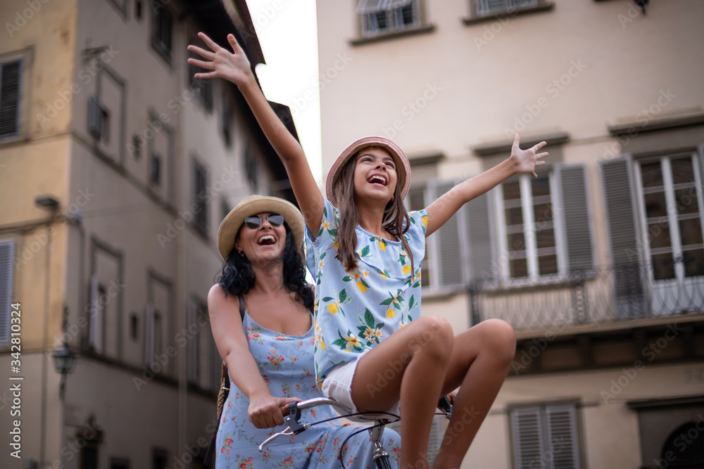 Φωτογραφία Happy caucasian mother and her daughter having fun with bicycle, little girl is