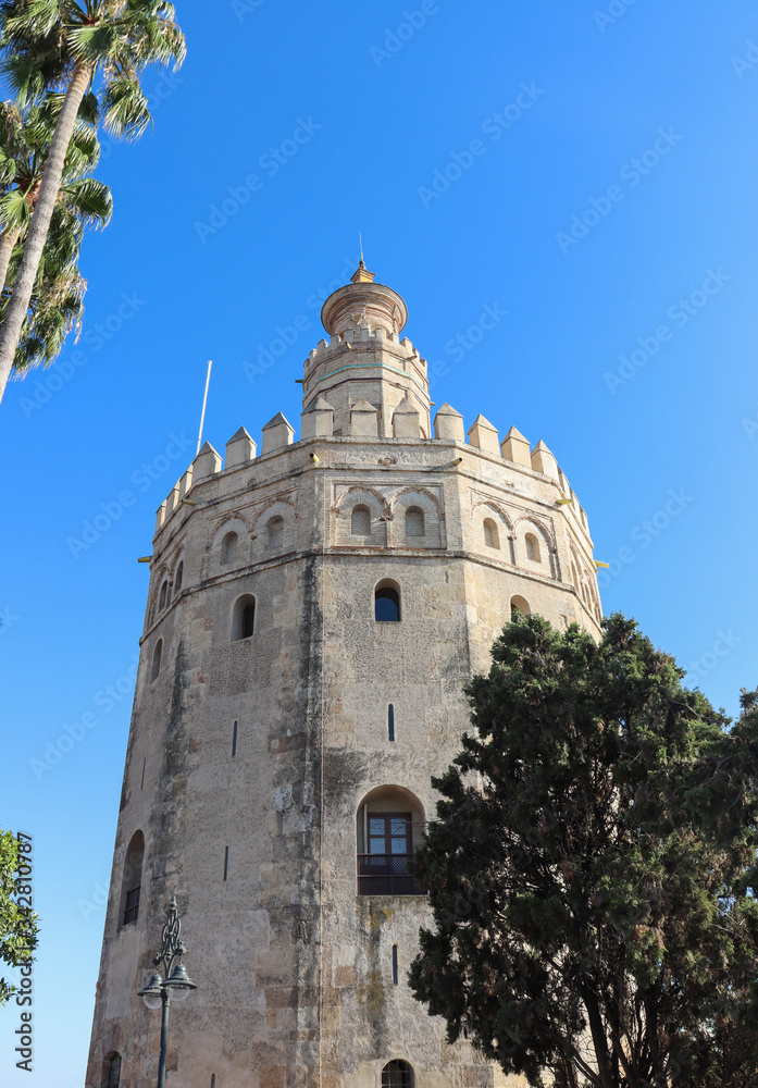 Historical building Tower of gold with green trees in a sunny day