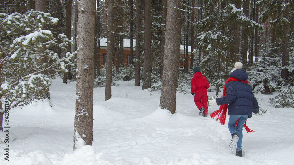 Family with children walks in the winter forest