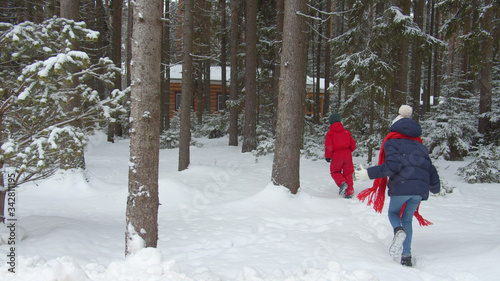 Family with children walks in the winter forest