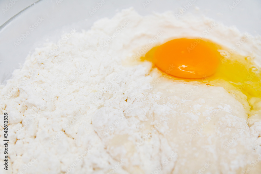 Preparation of the yeast dough. Dough with the egg`s yolk and flavour in the glass bowl is ready to be stirred. Preparation of the yeast dough. Dough with the egg`s yolk and flavour in the glass bowl is ready to be stirred.