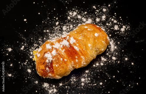 Close-up delicious cannoncino or puff pastry horn filled with custard. Traditional Italian food pastry. Black background photo