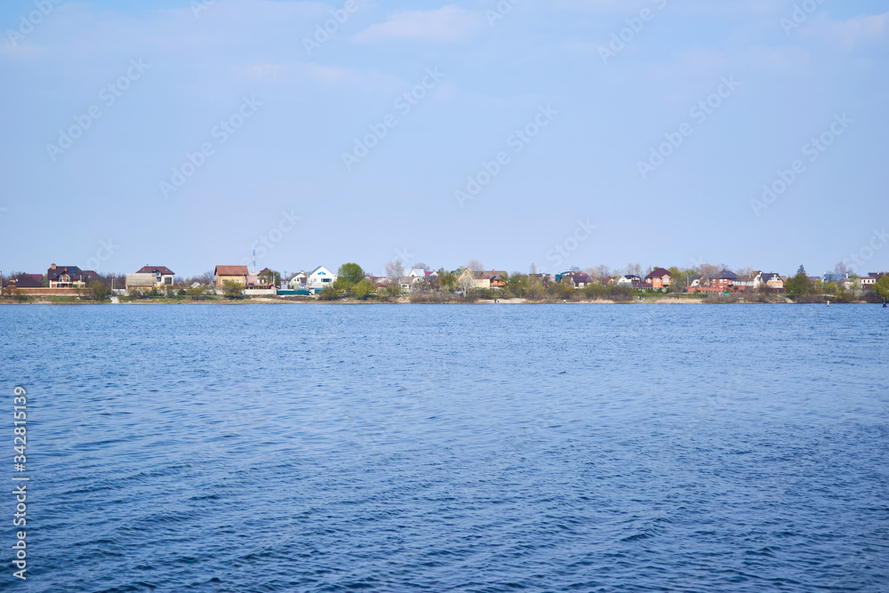 expanse of river water with houses on the shore.