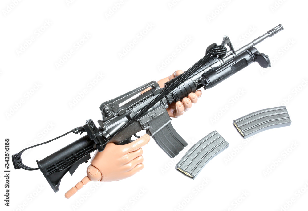 Metralhadora de brinquedo em miniatura nas mãos de action figure em fundo branco isolada. Arma em escala com acessórios.