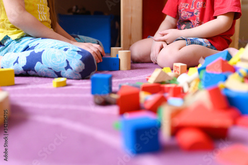 kids, sibling boy and girl plays at home with toys, wooden building blocks, during quarantine self isolation covid-19 corona virus