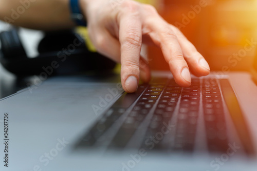 male hand typing on the keyboard a laptop. working man programmer. work from home. workplace with a laptop. selective focus. flare