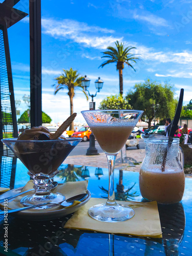 Enjoying cocktails with a view on the promenade and Mediterranean sea in Rapallo on a sunny day, Italy. Island vibes. photo