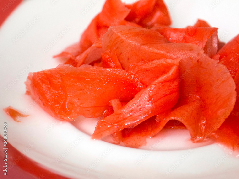 handul of red pickled ginger on the white plate handul of red pickled ginger on the white plate