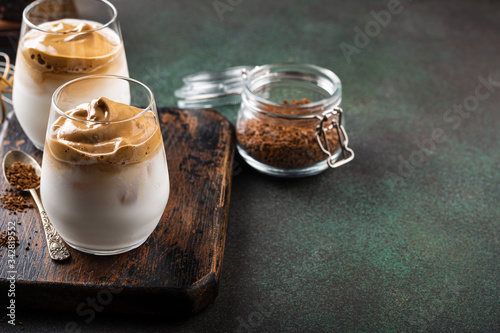 Dalgona coffee in glass cup. Korean trendy drink from instant coffee, milk and ice. Summer beverage concept with copy space.