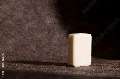 Minimal stylish concept with soap at brown background with sun shadows