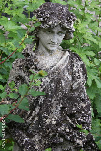 stone statue of a woman in a garden