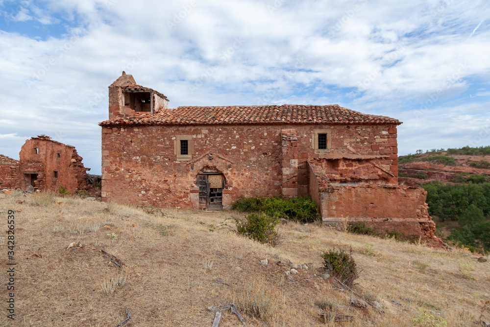 Ruins of an ancient church of red stone  and a broken door of wood
