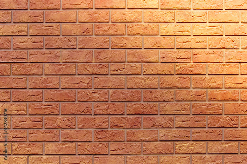Brick texture. Orange background. Brown wallpaper for designer. Rectangular photo, image with solar flare on the right.