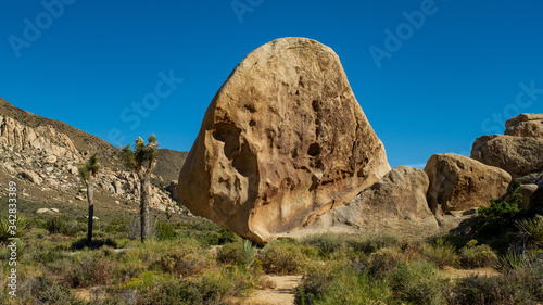ein riesiger alleinstehender Felsbrocken an einem Wegesrand