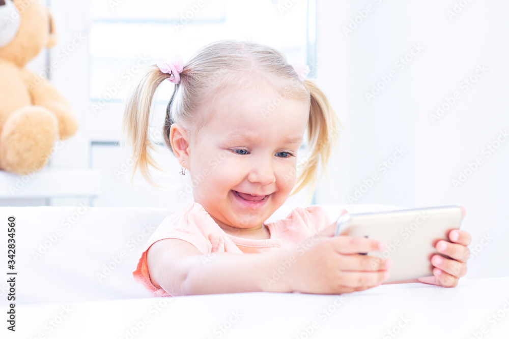 happy Girl using a mobile phone, a smartphone for video calls, talking with relatives, a girl sitting at home, online computer webcam, making a video call. happy Girl using a mobile phone, a smartphone for video calls, talking with relatives, a girl sitting at home, online computer webcam, making a video call.