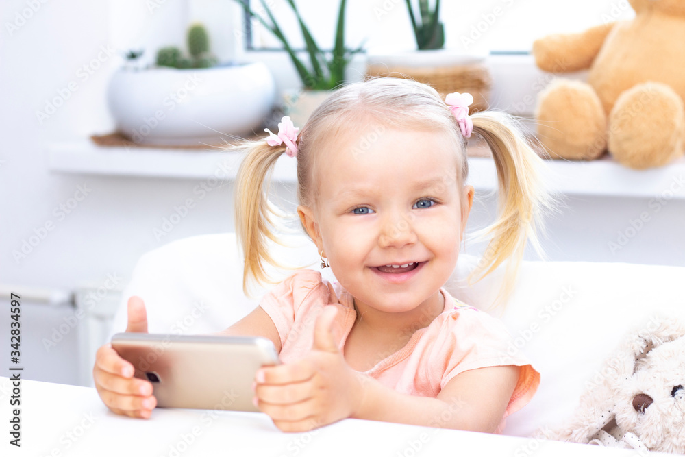 happy Girl using a mobile phone, a smartphone for video calls, talking with relatives, a girl sitting at home, online computer webcam, making a video call. happy Girl using a mobile phone, a smartphone for video calls, talking with relatives, a girl sitting at home, online computer webcam, making a video call.